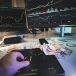 Jak wycenić licencję szkolną: modele cenowe, które działają w edtech Nowoczesne stanowisko traderów z wykresami rynkowymi i banknotami euro