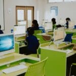 Dzieci uczące się przy komputerach w nowoczesnej pracowni szkolnej