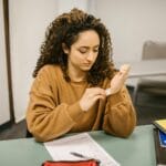 Uczennica spogląda na ściągę na ręce podczas klasówki