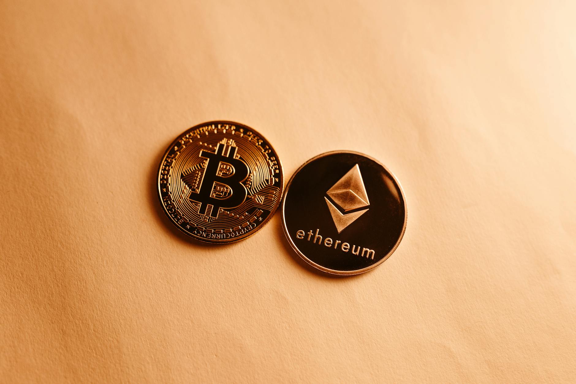 Monety Bitcoin i Ethereum na żółtym tle jako symbol finansowania