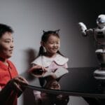Dwoje dzieci bawi się robotem na stole, poznając nową technologię