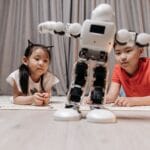Dzieci bawią się z humanoidalnym robotem na dywanie w domu