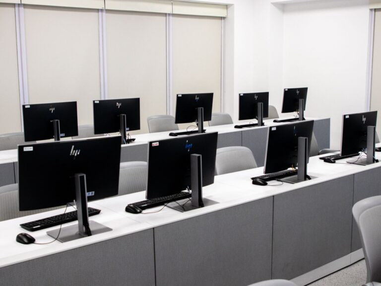 Pusta pracownia komputerowa z nowoczesnymi stanowiskami i fotelami